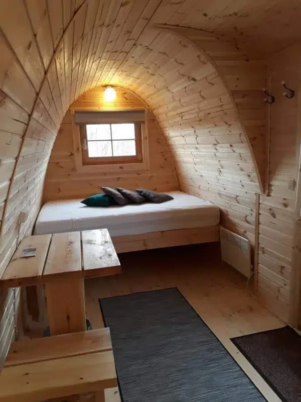 Wooden camping pod, interior bed and wooden table