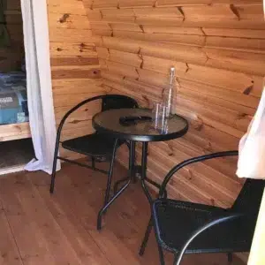 Wooden camping pod, interior round table and chairs