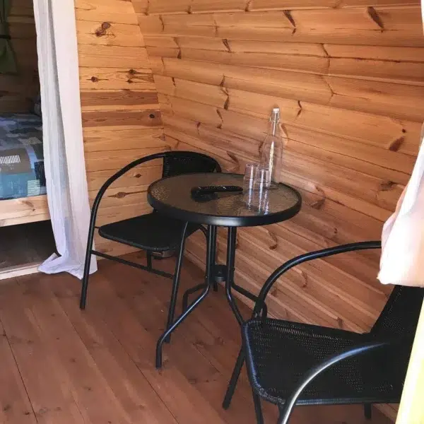 Wooden camping pod, interior round table and chairs