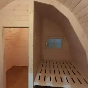 Wooden camping pod, interior sleeping platform and wooden partition