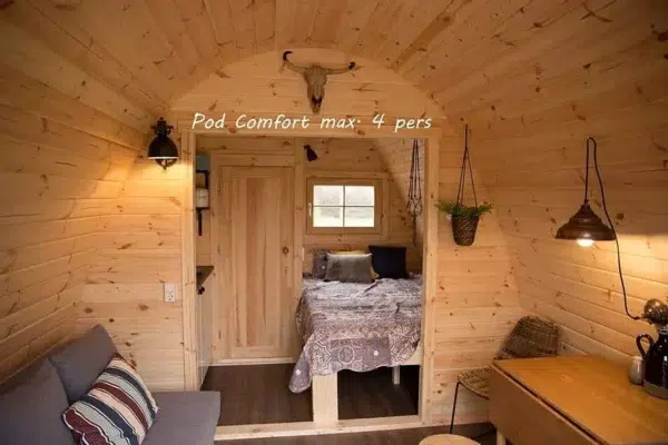 Wooden camping pod, interior sofa, dining area and separate bed