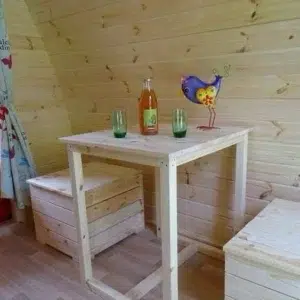 Wooden camping pod, interior table with benches