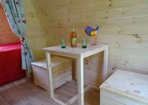 Wooden camping pod, interior table with benches
