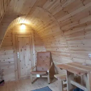 Wooden camping pod, interior table, chair and wooden partition