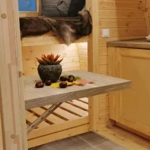 Wooden camping pod, interior table and raised sleeping area