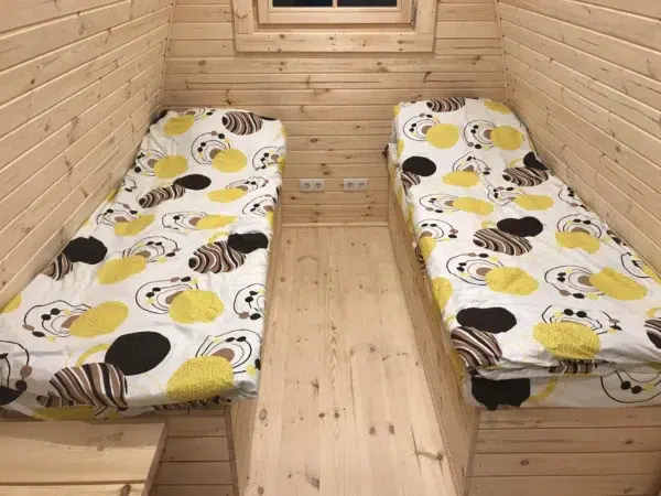 Wooden camping pod, interior twin beds with central aisle