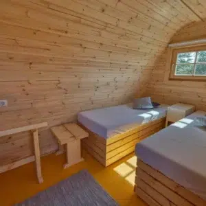 Wooden camping pod, interior twin beds and small stools