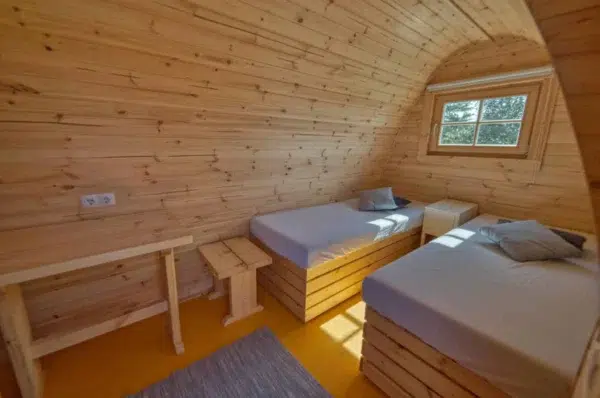 Wooden camping pod, interior twin beds and small stools