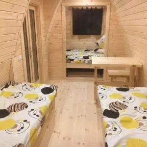 Wooden camping pod, interior with twin beds and small table