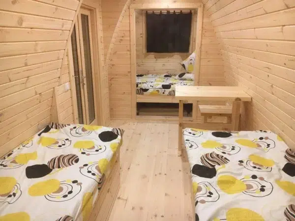Wooden camping pod, interior with twin beds and small table