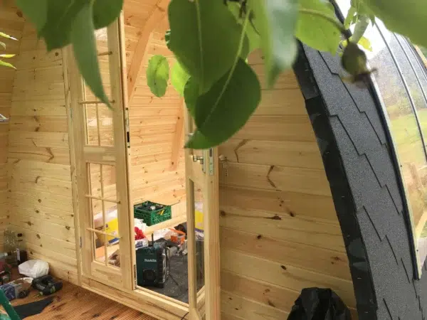 Wooden camping pod, interior view of curved roof glazing