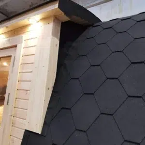 Wooden camping pod, junction of side entrance canopy and shingle roof