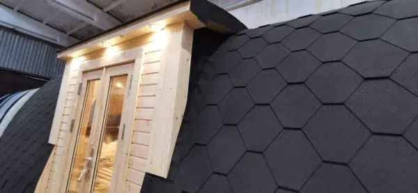 Wooden camping pod, junction of side entrance canopy and shingle roof
