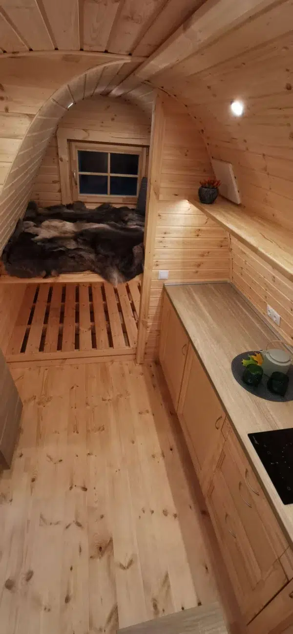Wooden camping pod, kitchenette and raised sleeping platforms