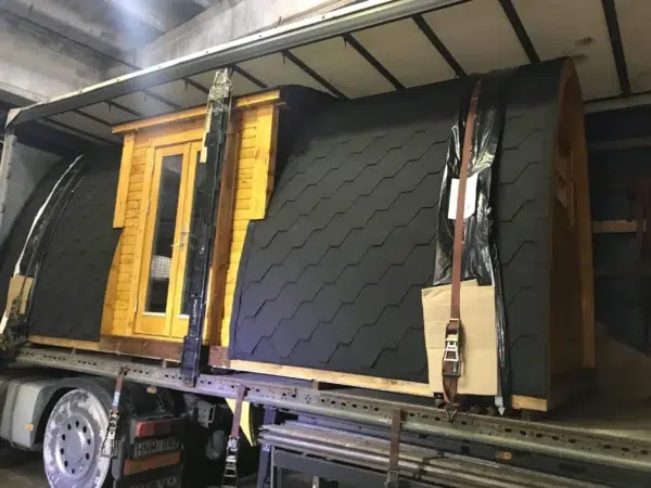 Wooden camping pod, loaded on a transport truck