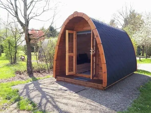 Wooden camping pod, open front doors revealing interior