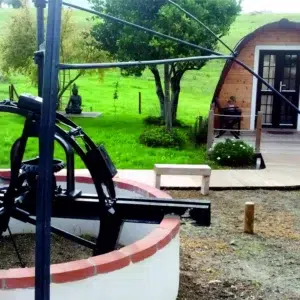 Wooden camping pod, outdoor seating area beside camping pod