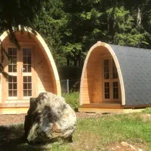Wooden camping pod, pair of camping pods in a landscaped setting