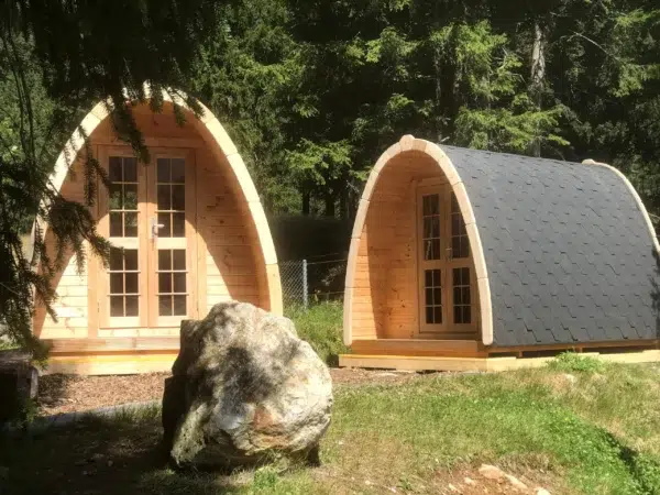 Wooden camping pod, pair of camping pods in a landscaped setting
