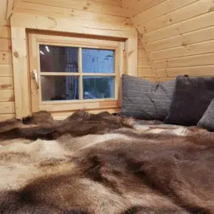 Wooden camping pod, raised bed beneath rear window