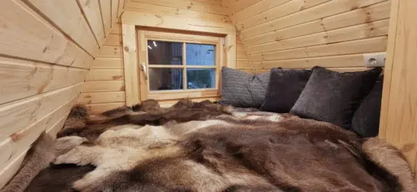 Wooden camping pod, raised bed beneath rear window