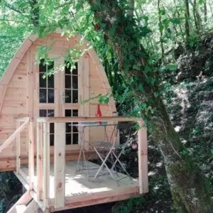 Wooden camping pod, raised entrance deck in a wooded setting