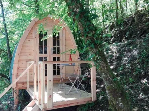 Wooden camping pod, raised entrance deck in a wooded setting
