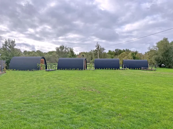 Wooden camping pod, row of camping pods on a lawn