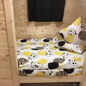 Wooden camping pod, separate sleeping area with patterned bedding