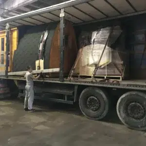Wooden camping pod, several pods secured on a transport truck