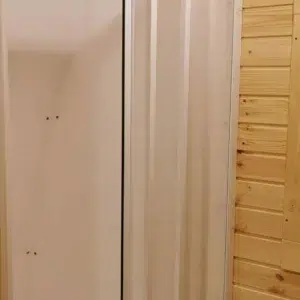 Wooden camping pod, shower enclosure beside wooden wall