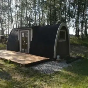 Wooden camping pod, side and end exterior in a woodland setting
