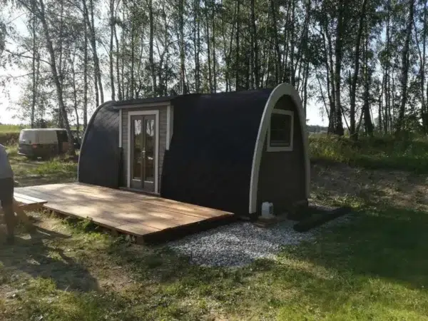 Wooden camping pod, side and end exterior in a woodland setting