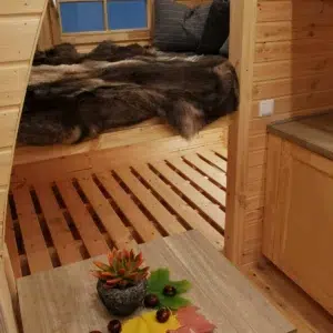 Wooden camping pod, sleeping area and kitchenette