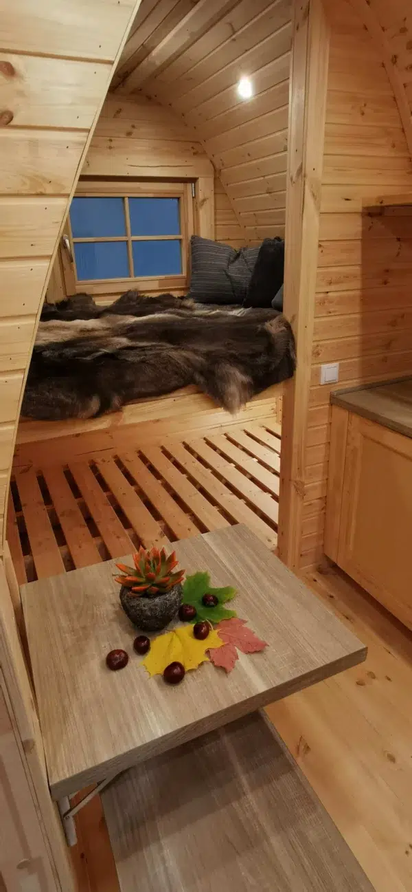 Wooden camping pod, sleeping area and kitchenette