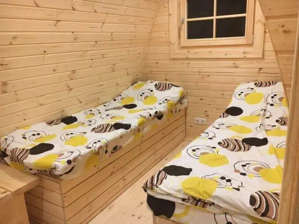 Wooden camping pod, twin beds beneath rear window