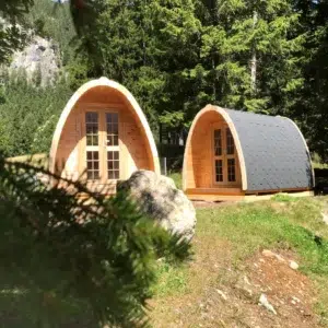 Wooden camping pod, two camping pods among trees
