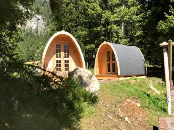 Wooden camping pod, two camping pods among trees