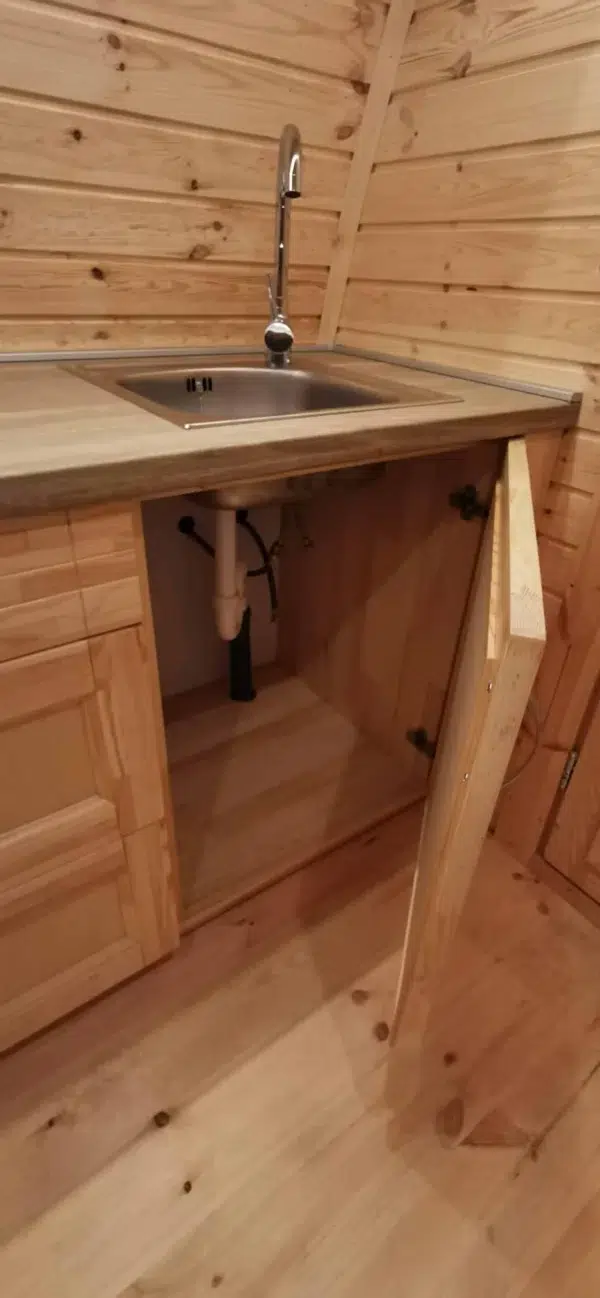 Wooden camping pod, under-sink cabinet storage and plumbing