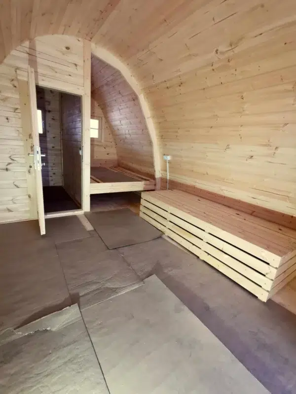 Wooden camping pod, unfinished interior with stacked boards