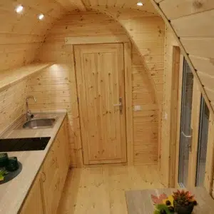 Wooden camping pod, view along kitchenette to internal door
