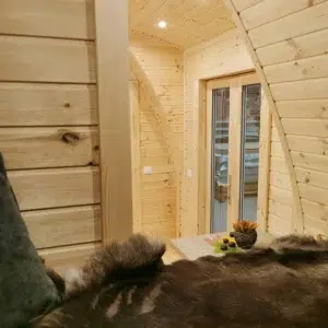 Wooden camping pod, view from bed toward glazed side entrance