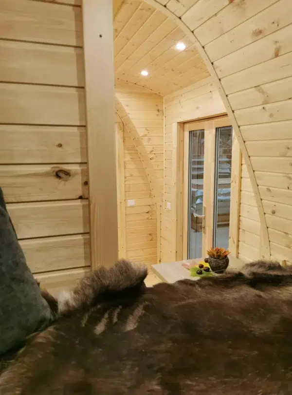 Wooden camping pod, view from bed toward glazed side entrance