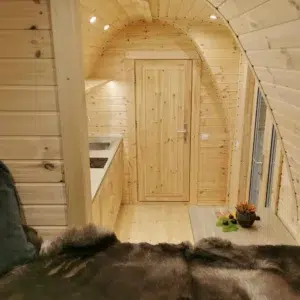 Wooden camping pod, view from raised bed toward kitchenette