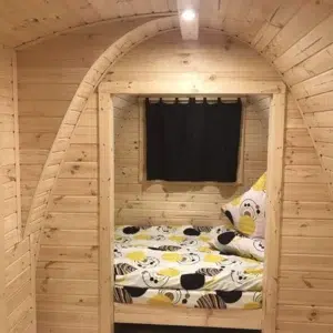 Wooden camping pod, view through partition to separate sleeping area