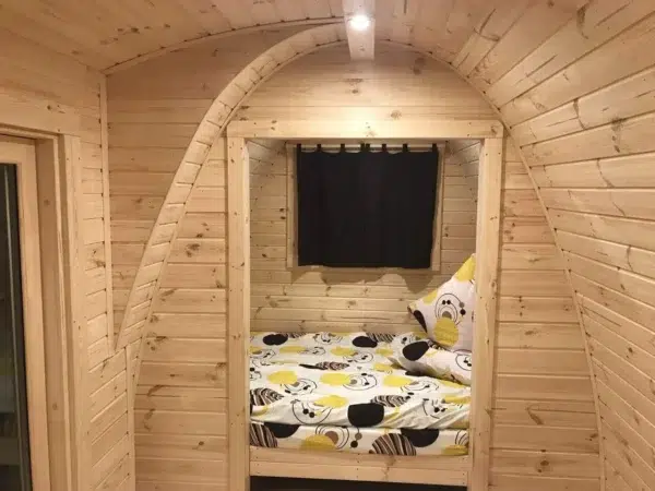 Wooden camping pod, view through partition to separate sleeping area