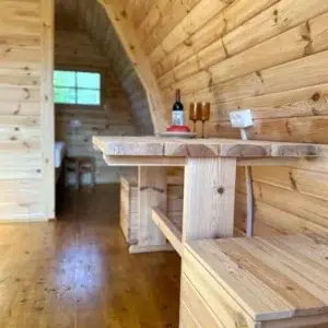Wooden camping pod, wooden dining table and bench