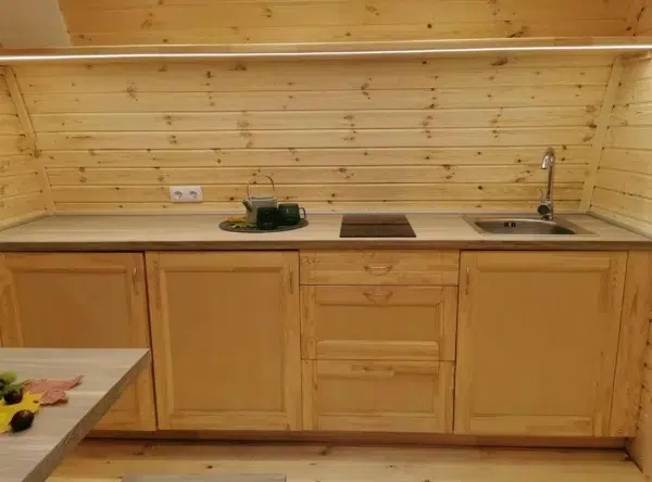 Wooden camping pod, wooden kitchenette with sink and hob