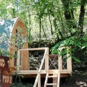 Wooden camping pod, woodland front entrance with railing