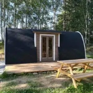 Wooden camping pod, woodland installation with entrance deck and picnic table